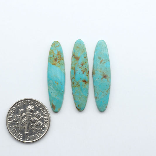 Hubei Cloud Mountain Turquoise cabochons, blue and green color with black matrix, polished stones on a white background, with a US dime for scale