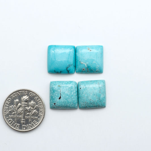 Hubei Cloud Mountain Turquoise cabochons, blue and green color with black matrix, polished stones on a white background, with a US dime for scale