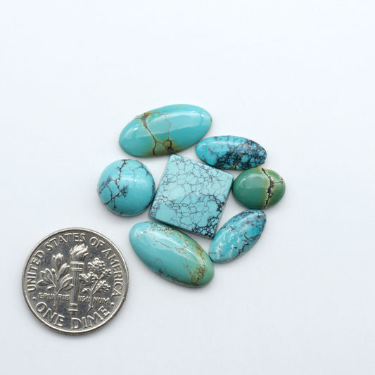 Hubei Cloud Mountain Turquoise cabochons, blue and green color with black matrix, polished stones on a white background, with a US dime for scale