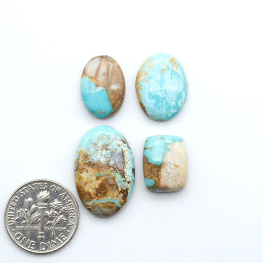Royston Turquoise cabochons, blue-green color with natural matrix, polished stones on a white background, with a US dime for scale