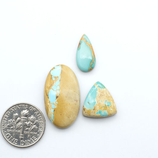 Royston Turquoise cabochons, blue-green color with natural matrix, polished stones on a white background, with a US dime for scale