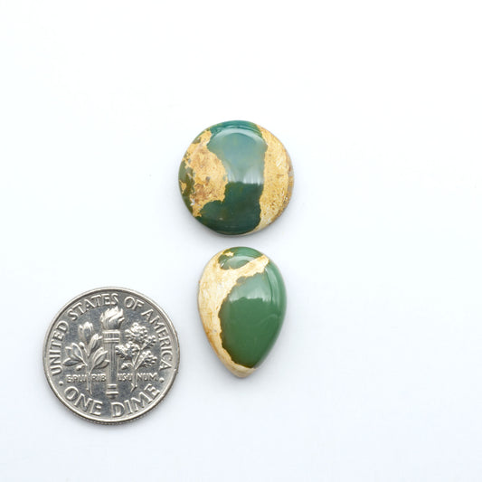 Royston Turquoise cabochons, blue-green color with natural matrix, polished stones on a white background, with a US dime for scale