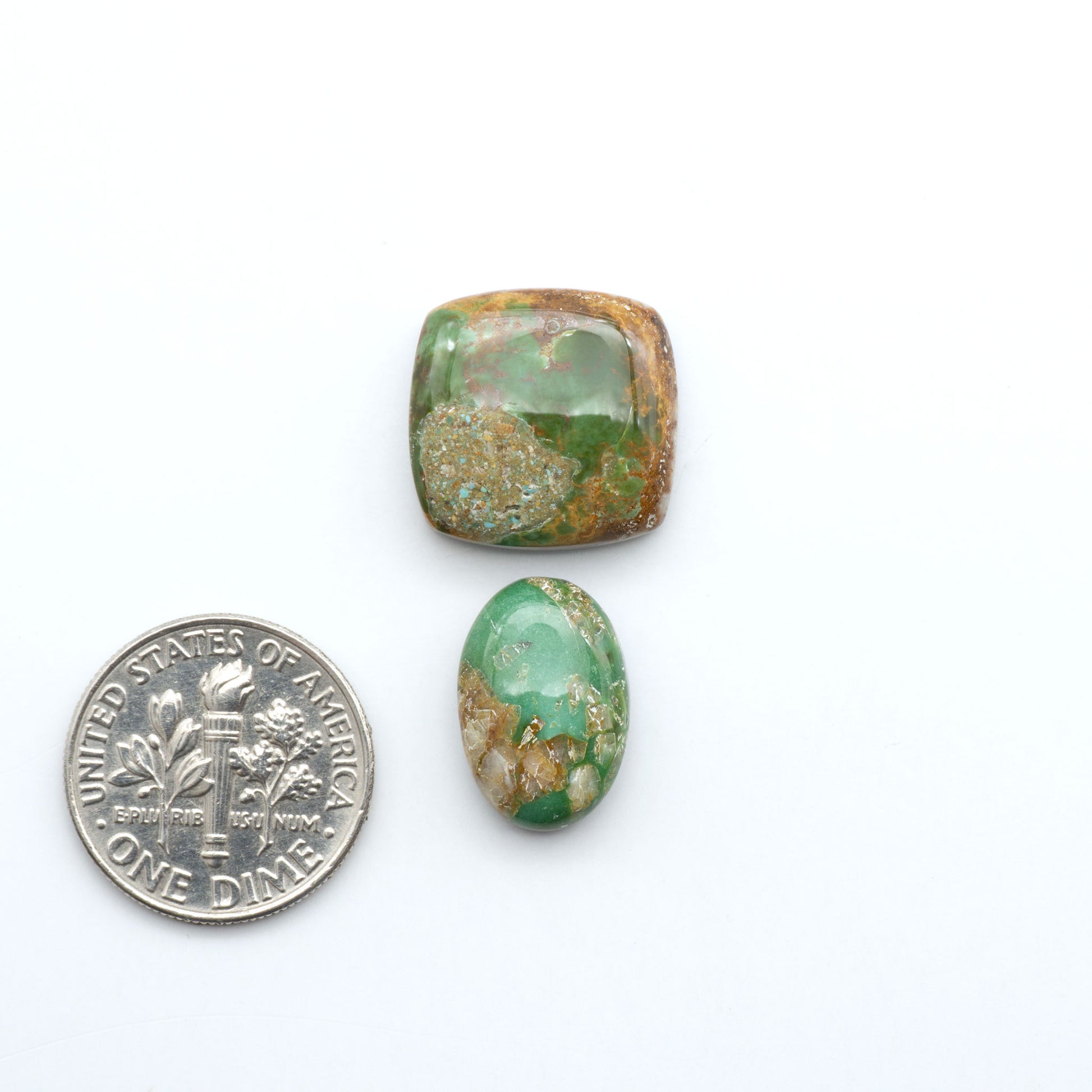 Royston Turquoise cabochons, blue-green color with natural matrix, polished stones on a white background, with a US dime for scale