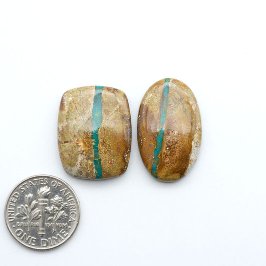 Royston Turquoise cabochons, blue-green color with natural matrix, polished stones on a white background, with a US dime for scale