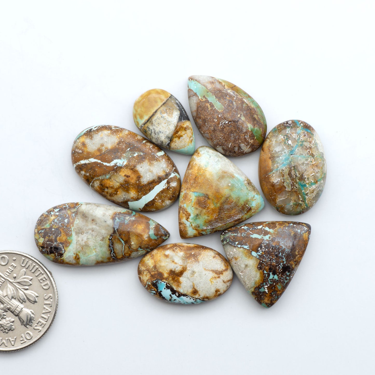 Royston Turquoise cabochons, blue-green color with natural matrix, polished stones on a white background, with a US dime for scale