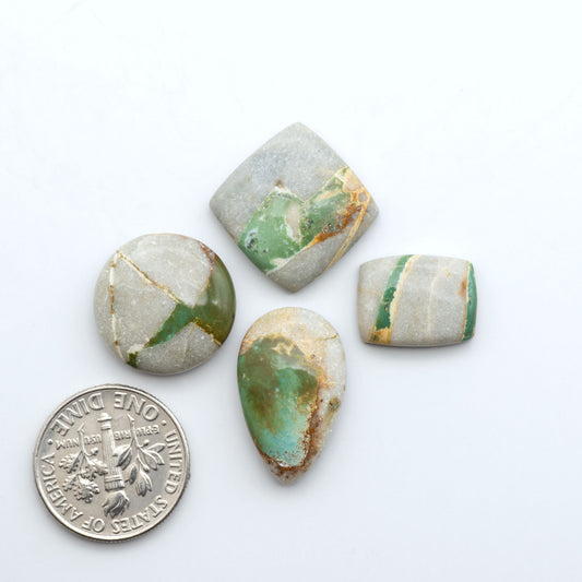 Royston Turquoise cabochons, blue-green color with natural matrix, polished stones on a white background, with a US dime for scale