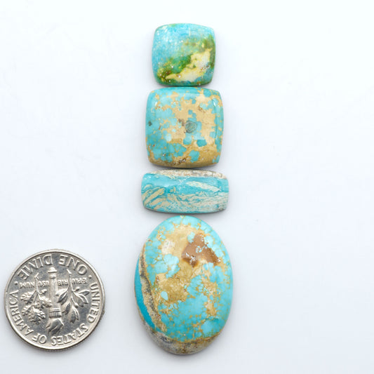 Royston Turquoise cabochons, blue-green color with natural matrix, polished stones on a white background, with a US dime for scale