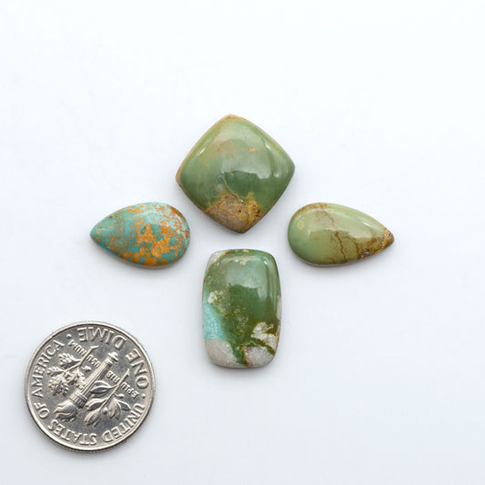 Royston Turquoise cabochons, blue-green color with natural matrix, polished stones on a white background, with a US dime for scale