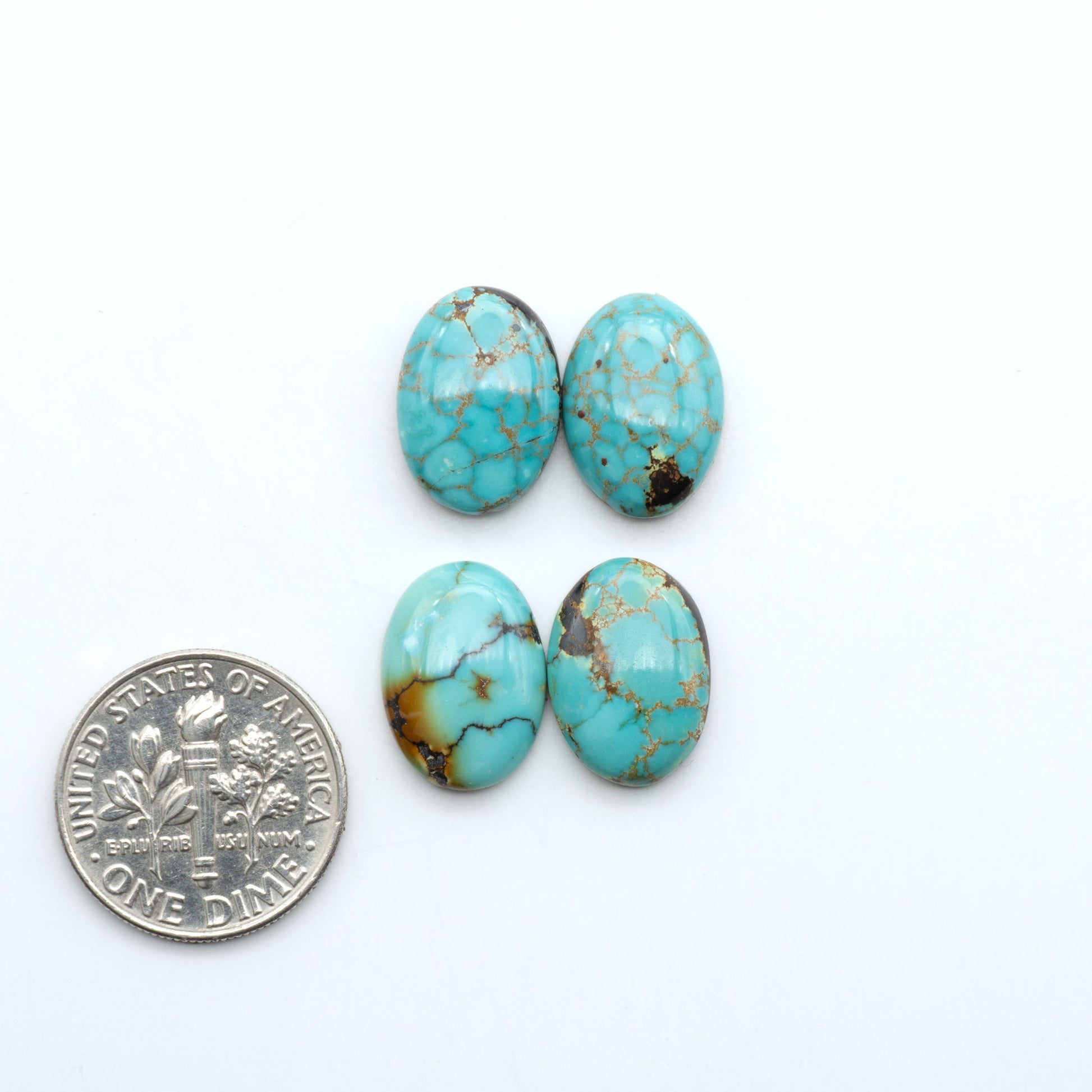 Hubei Cloud Mountain Turquoise cabochons, blue and green color with black matrix, polished stones on a white background, with a US dime for scale