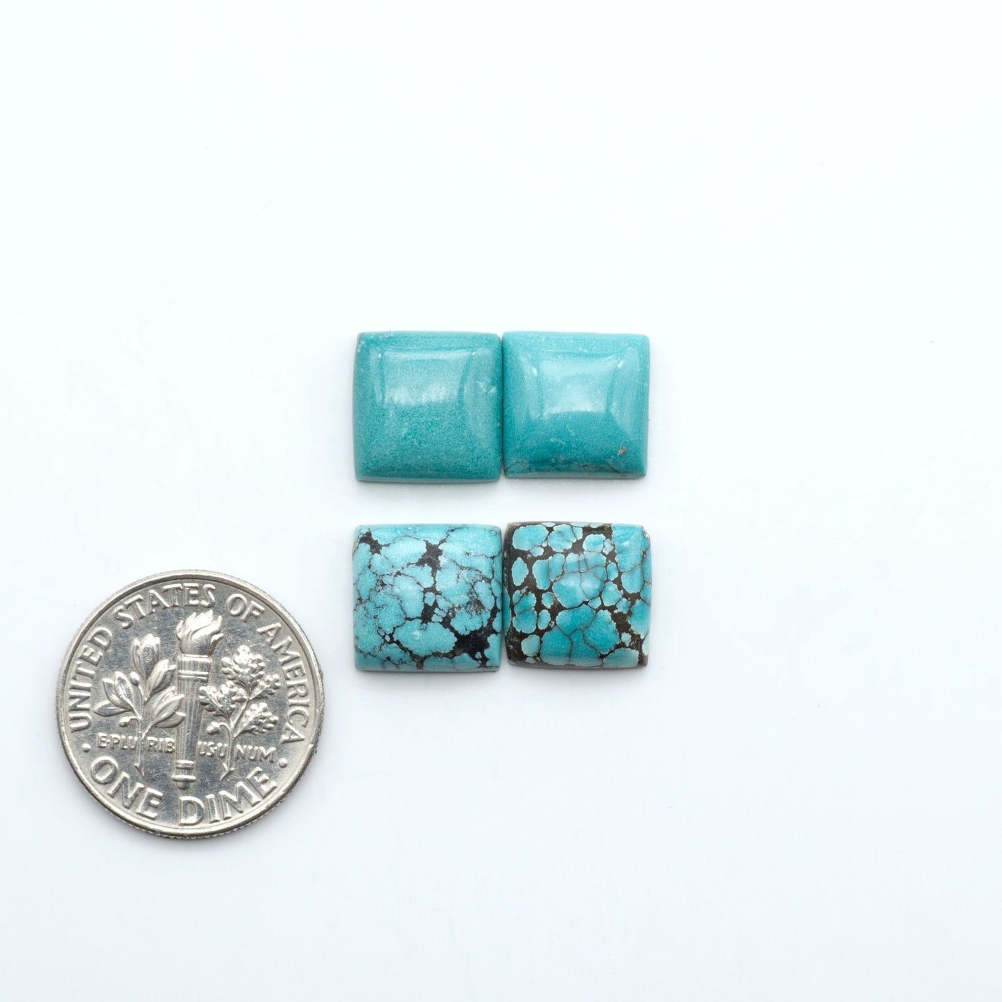 Hubei Cloud Mountain Turquoise cabochons, blue and green color with black matrix, polished stones on a white background, with a US dime for scale