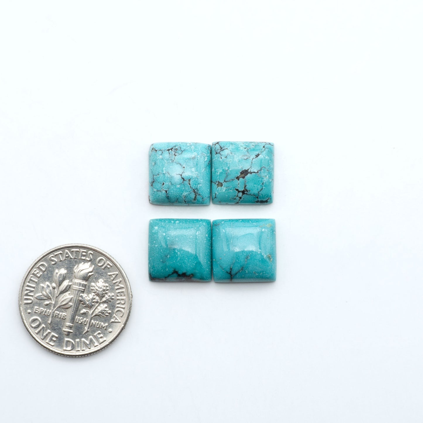 Hubei Cloud Mountain Turquoise cabochons, blue and green color with black matrix, polished stones on a white background, with a US dime for scale