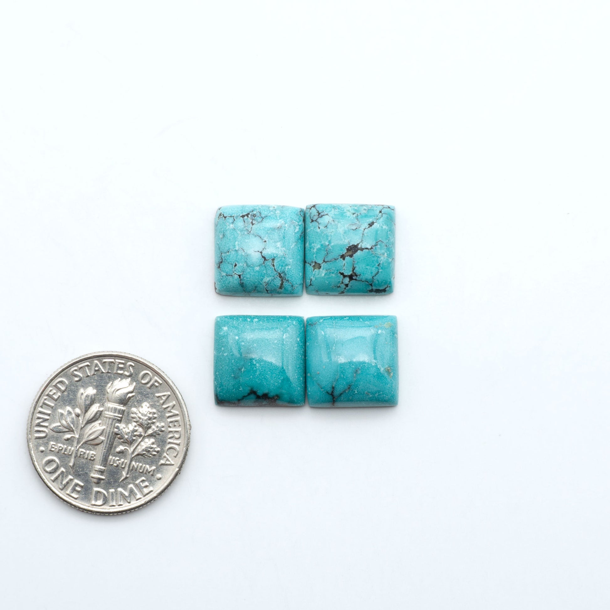 Hubei Cloud Mountain Turquoise cabochons, blue and green color with black matrix, polished stones on a white background, with a US dime for scale