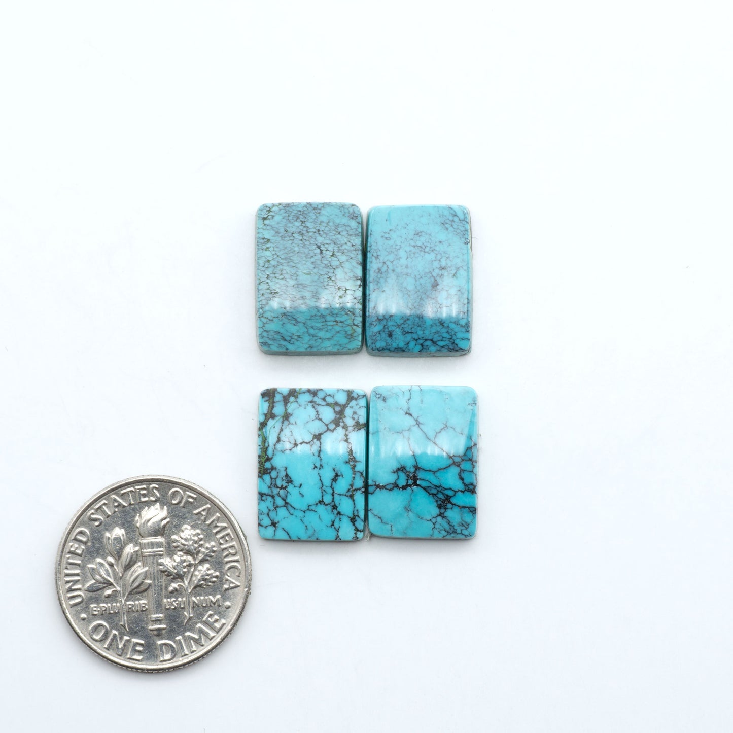 Hubei Cloud Mountain Turquoise cabochons, blue and green color with black matrix, polished stones on a white background, with a US dime for scale
