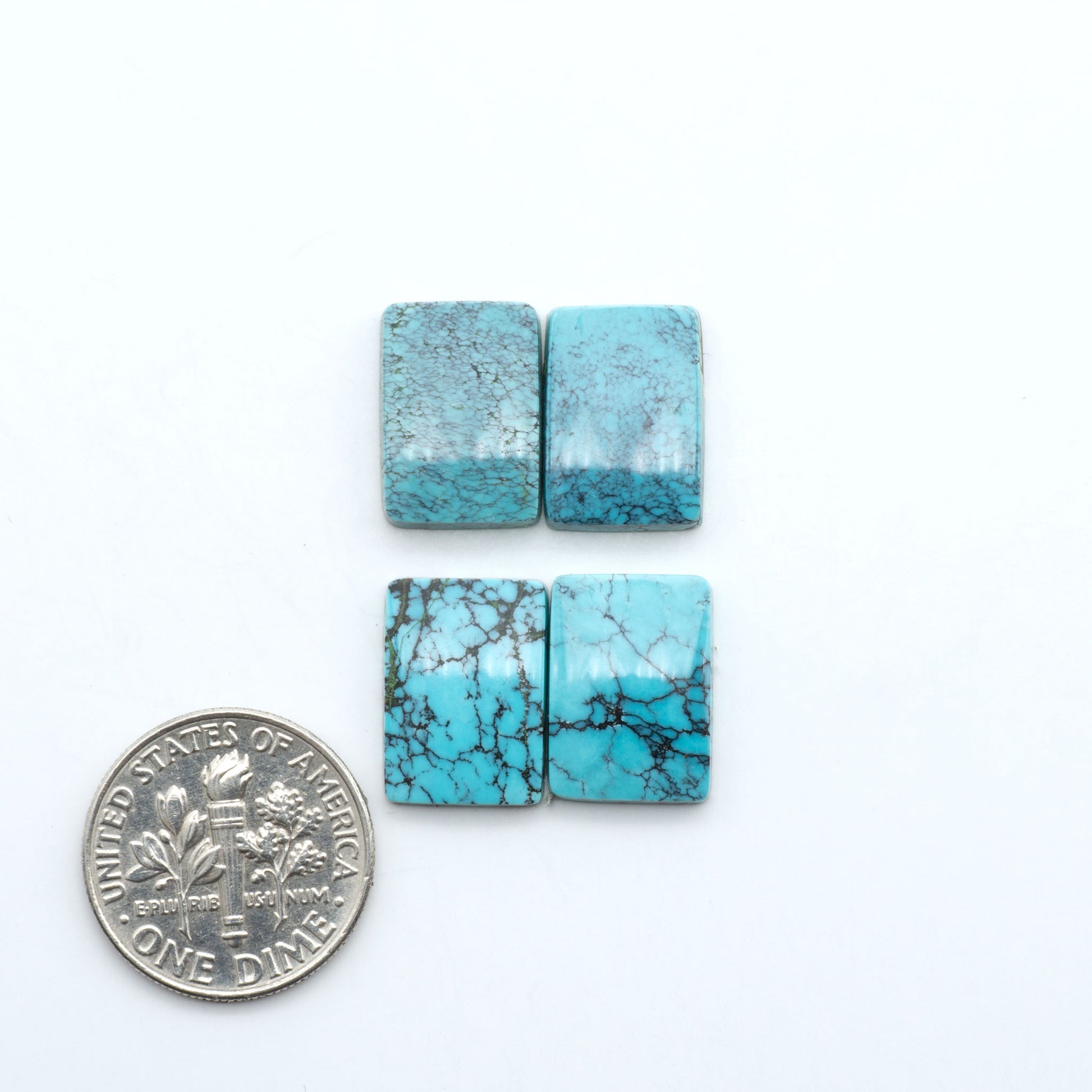 Hubei Cloud Mountain Turquoise cabochons, blue and green color with black matrix, polished stones on a white background, with a US dime for scale