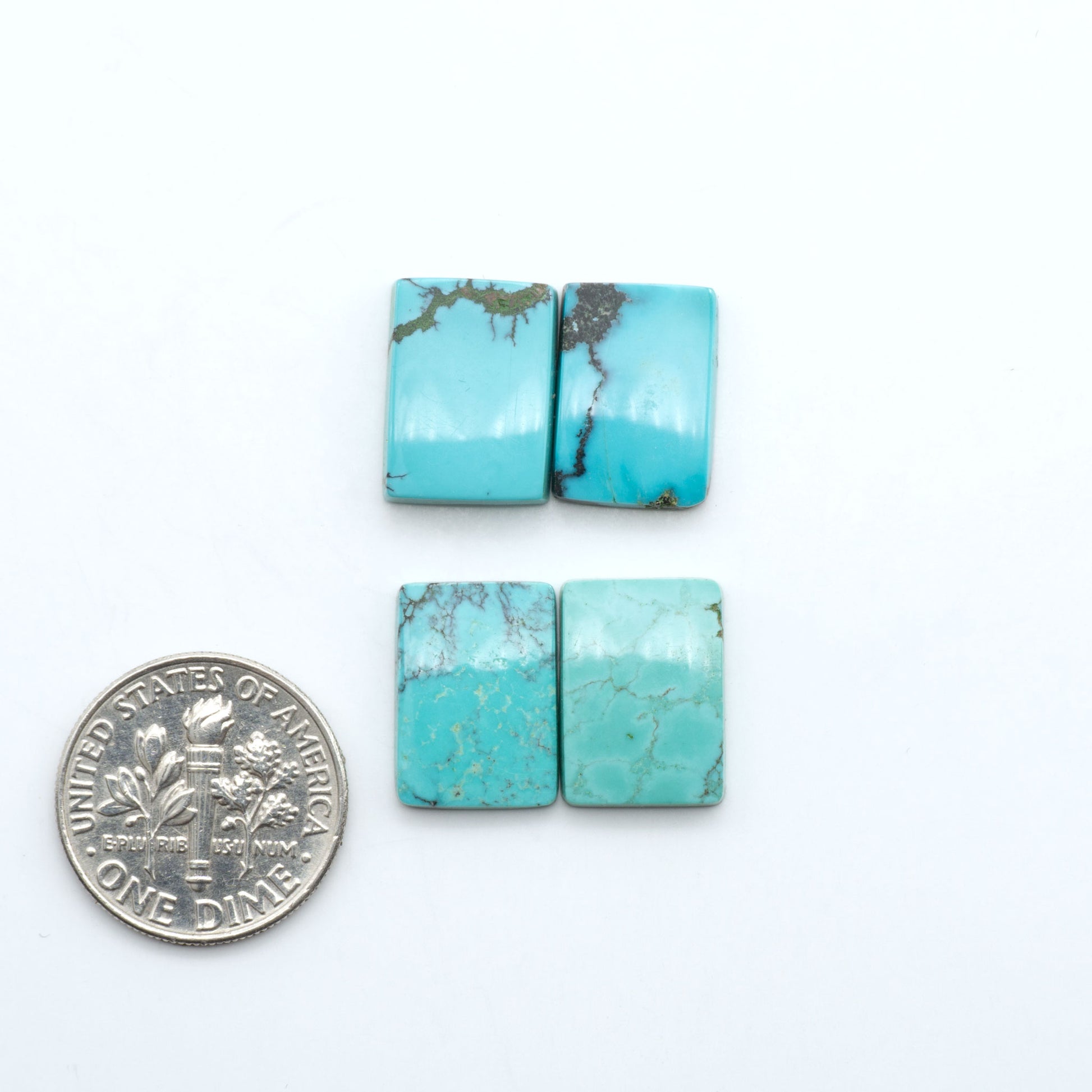 Hubei Cloud Mountain Turquoise cabochons, blue and green color with black matrix, polished stones on a white background, with a US dime for scale