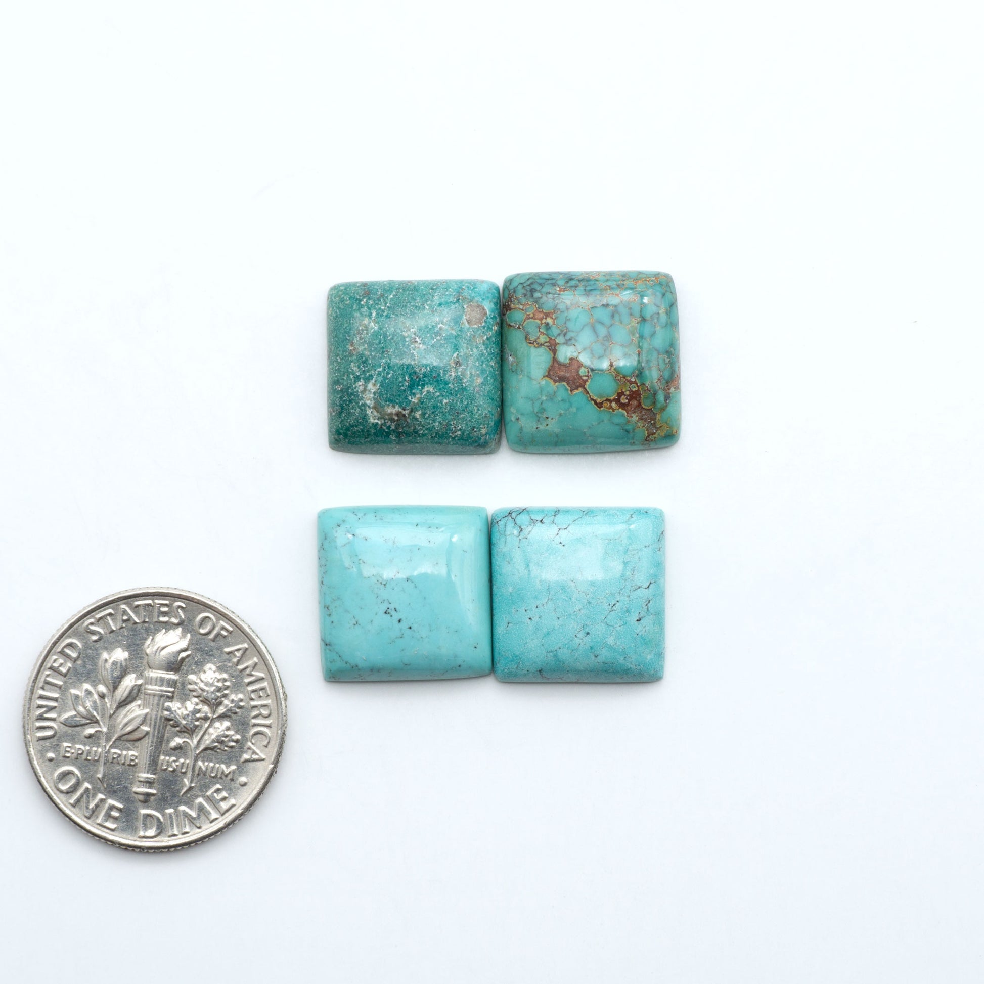 Hubei Cloud Mountain Turquoise cabochons, blue and green color with black matrix, polished stones on a white background, with a US dime for scale