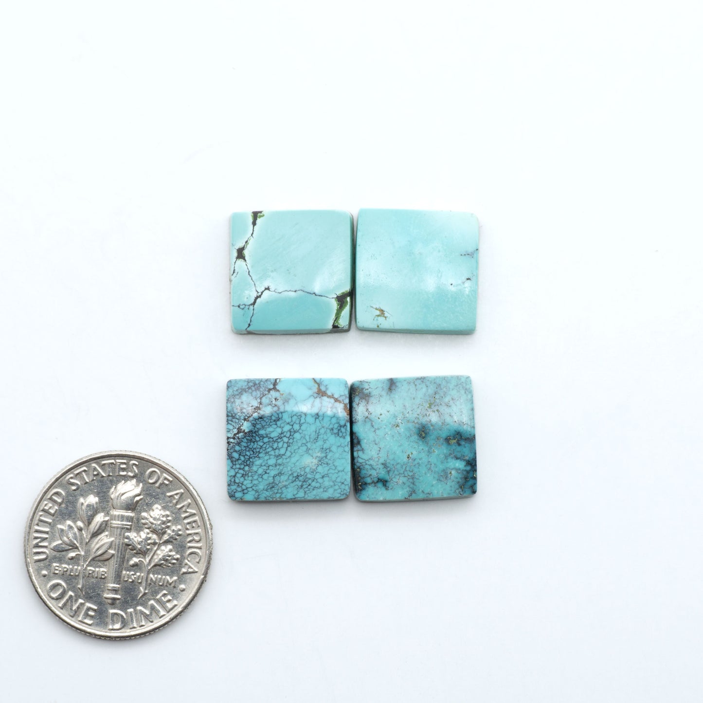 Hubei Cloud Mountain Turquoise cabochons, blue and green color with black matrix, polished stones on a white background, with a US dime for scale