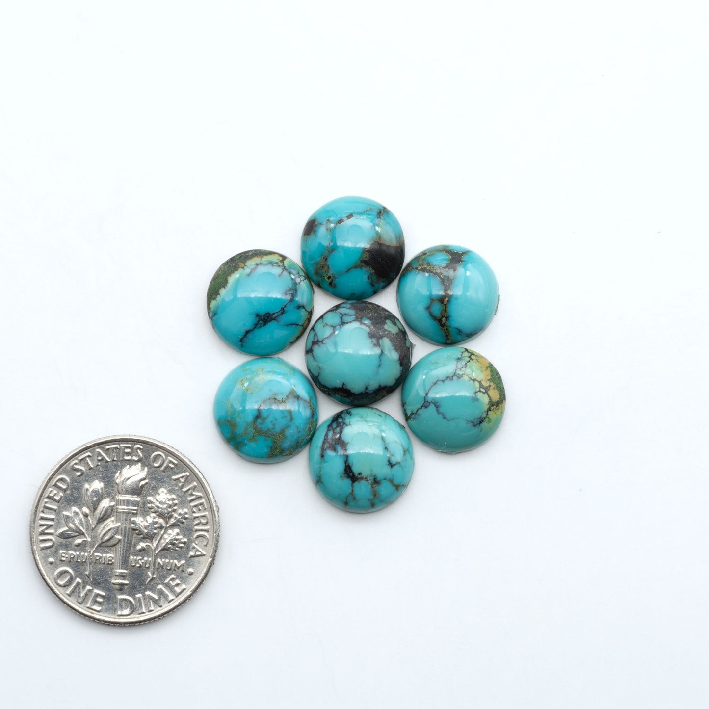 Hubei Cloud Mountain Turquoise cabochons, blue and green color with black matrix, polished stones on a white background, with a US dime for scale