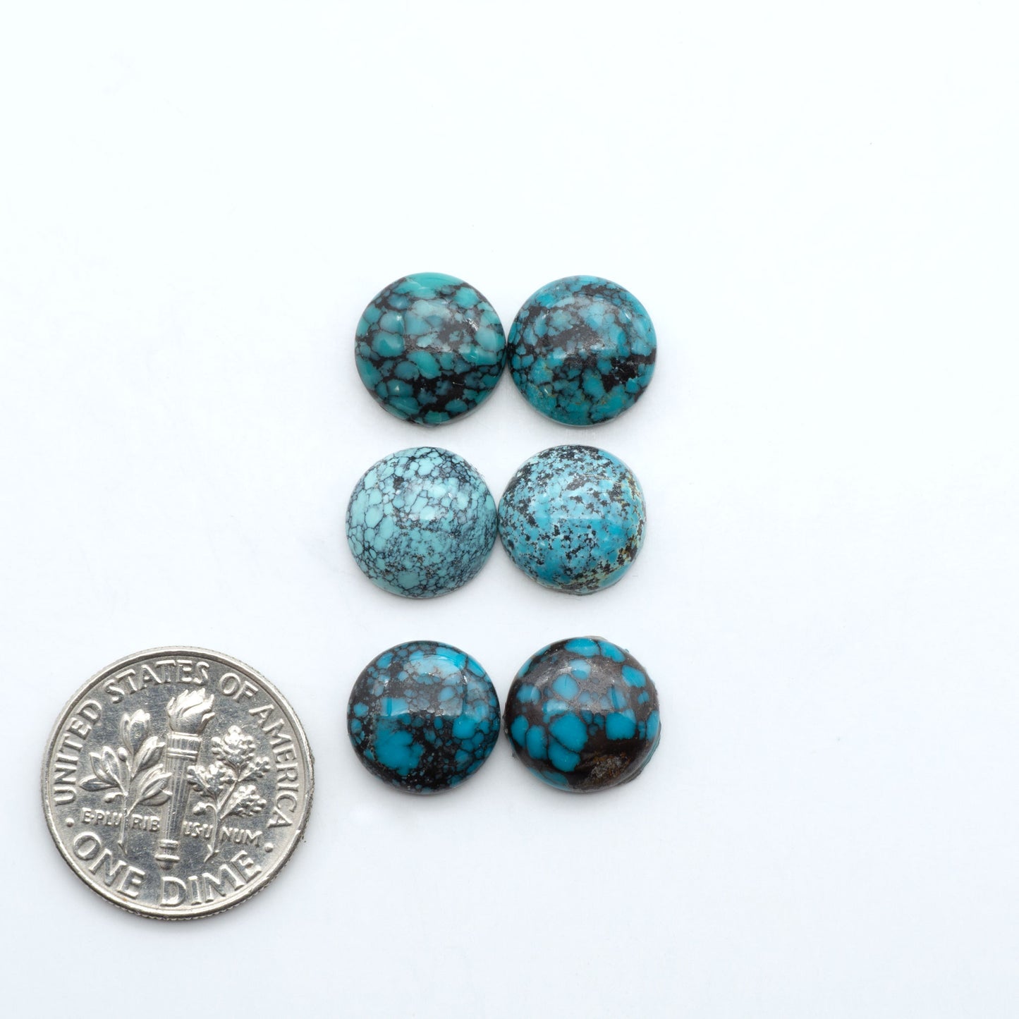 Hubei Cloud Mountain Turquoise cabochons, blue and green color with black matrix, polished stones on a white background, with a US dime for scale