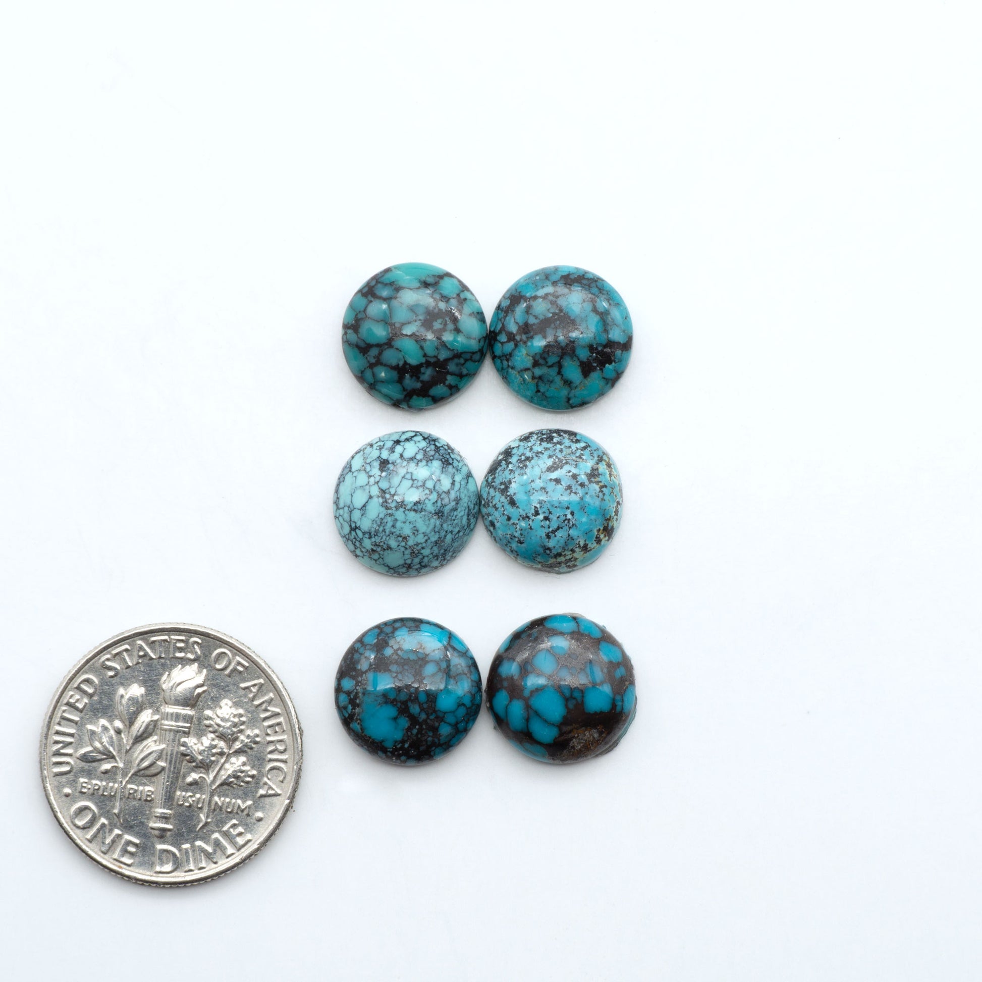 Hubei Cloud Mountain Turquoise cabochons, blue and green color with black matrix, polished stones on a white background, with a US dime for scale