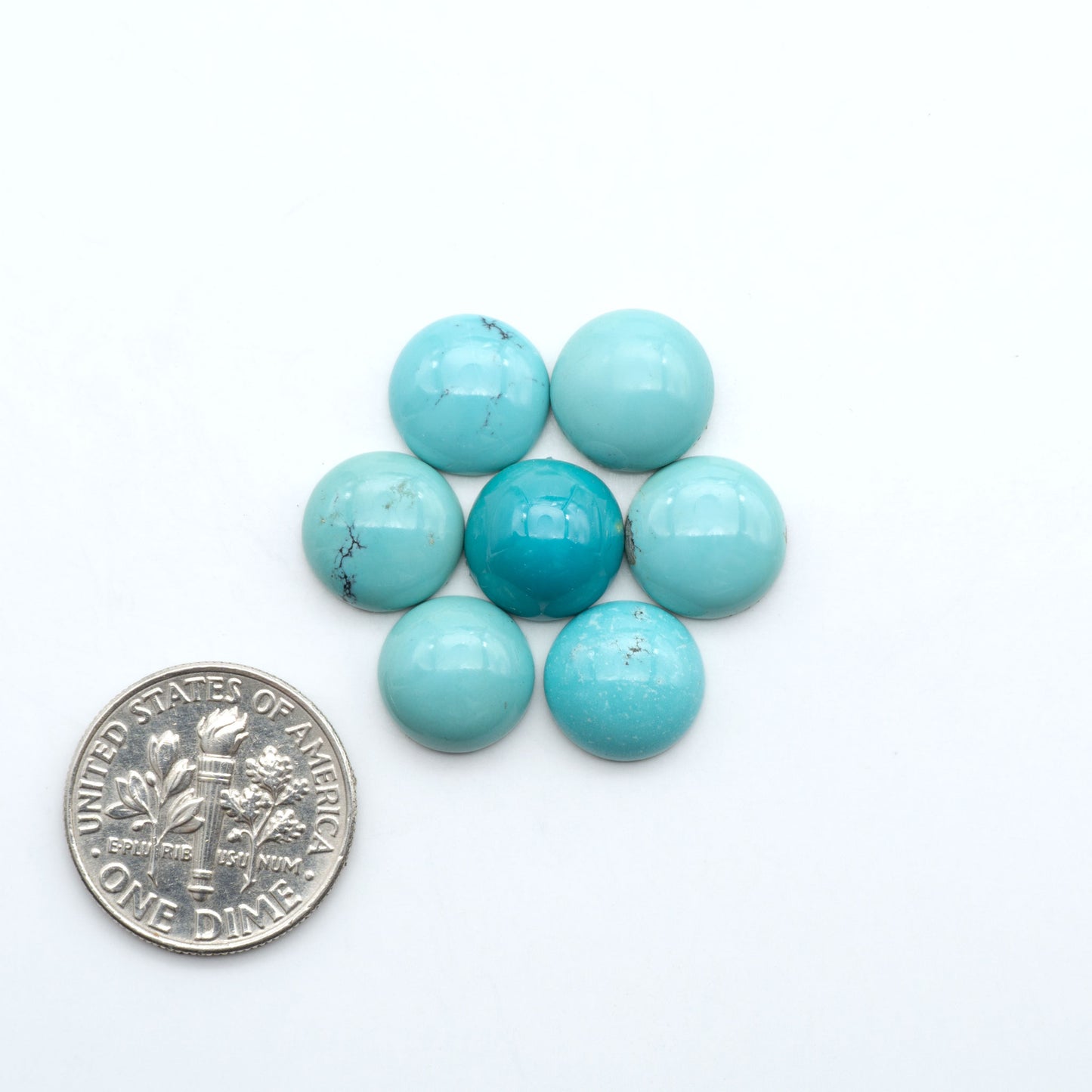 Hubei Cloud Mountain Turquoise cabochons, blue and green color with black matrix, polished stones on a white background, with a US dime for scale