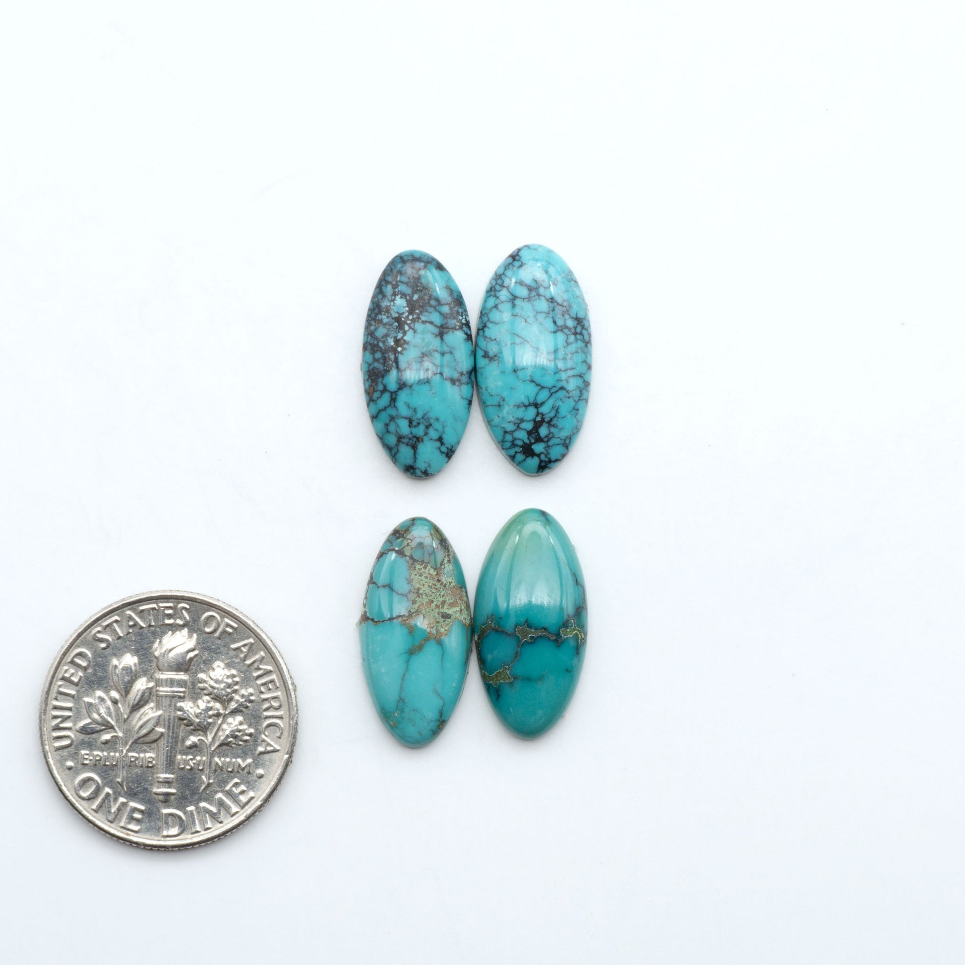 Hubei Cloud Mountain Turquoise cabochons, blue and green color with black matrix, polished stones on a white background, with a US dime for scale