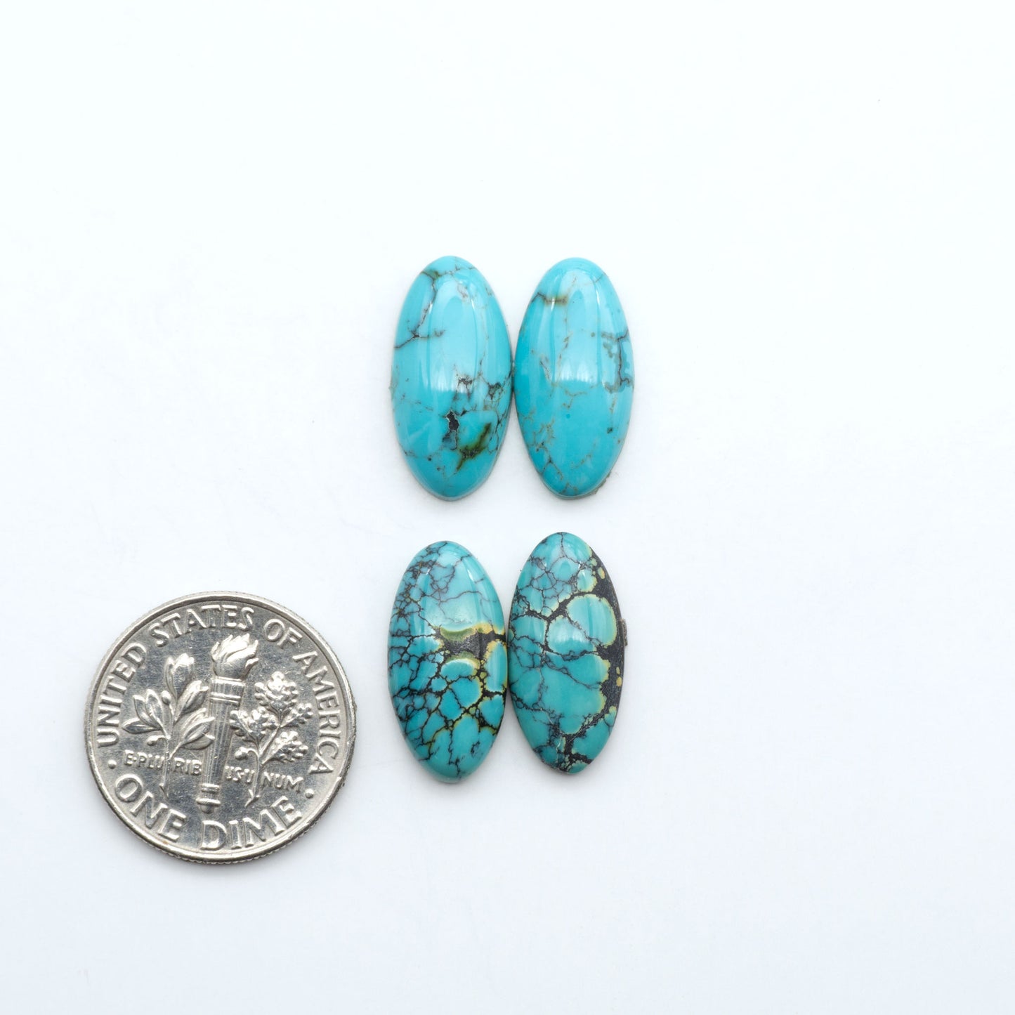 Hubei Cloud Mountain Turquoise cabochons, blue and green color with black matrix, polished stones on a white background, with a US dime for scale
