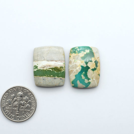 Royston Turquoise cabochons, blue-green color with natural matrix, polished stones on a white background, with a US dime for scale
