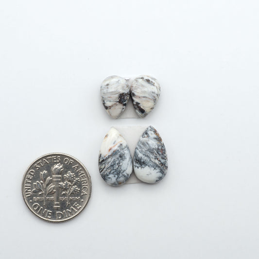 White Buffalo stone cabochons, white stone with black matrix, polished stones on a white background, with a US dime for scale