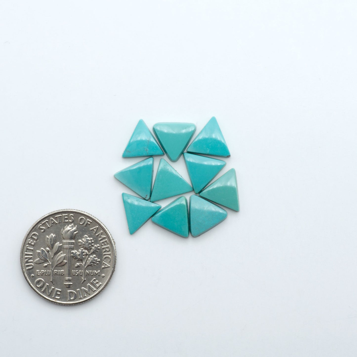 Hubei Cloud Mountain Turquoise cabochons, blue and green color with black matrix, polished stones on a white background with a US dime for scale
