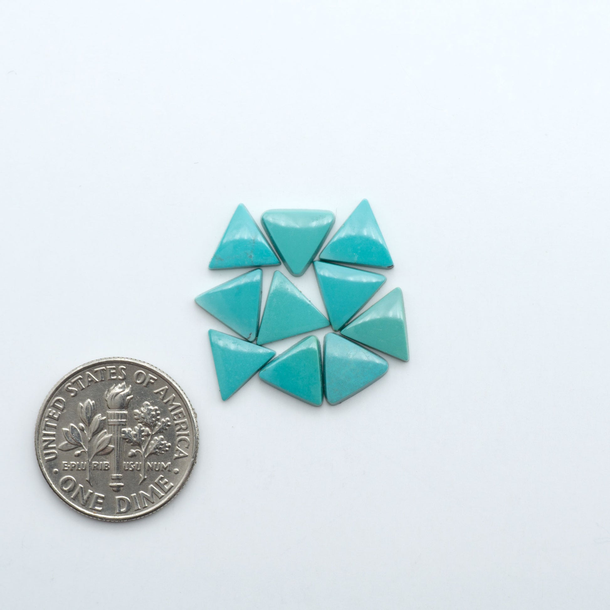 Hubei Cloud Mountain Turquoise cabochons, blue and green color with black matrix, polished stones on a white background with a US dime for scale