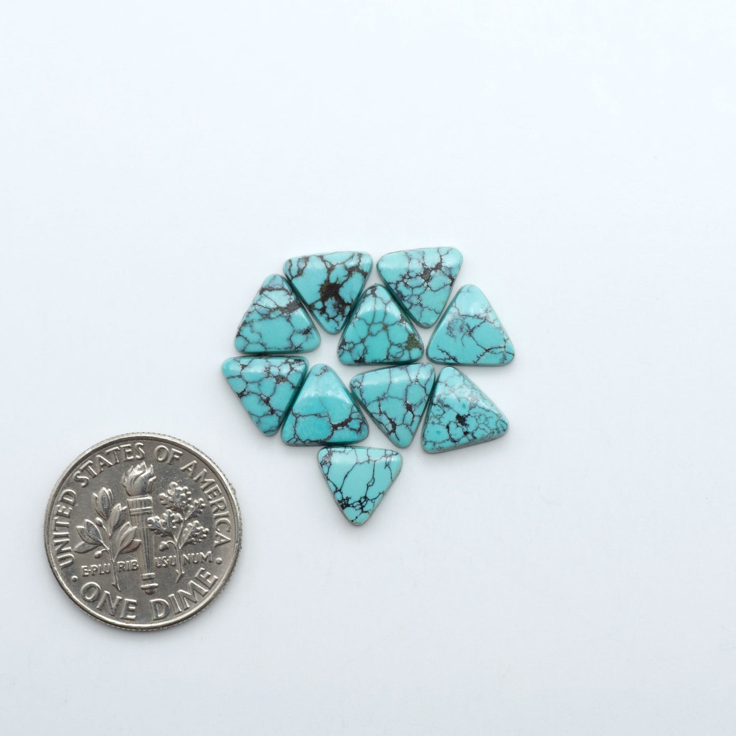 Hubei Cloud Mountain Turquoise cabochons, blue and green color with black matrix, polished stones on a white background with a US dime for scale