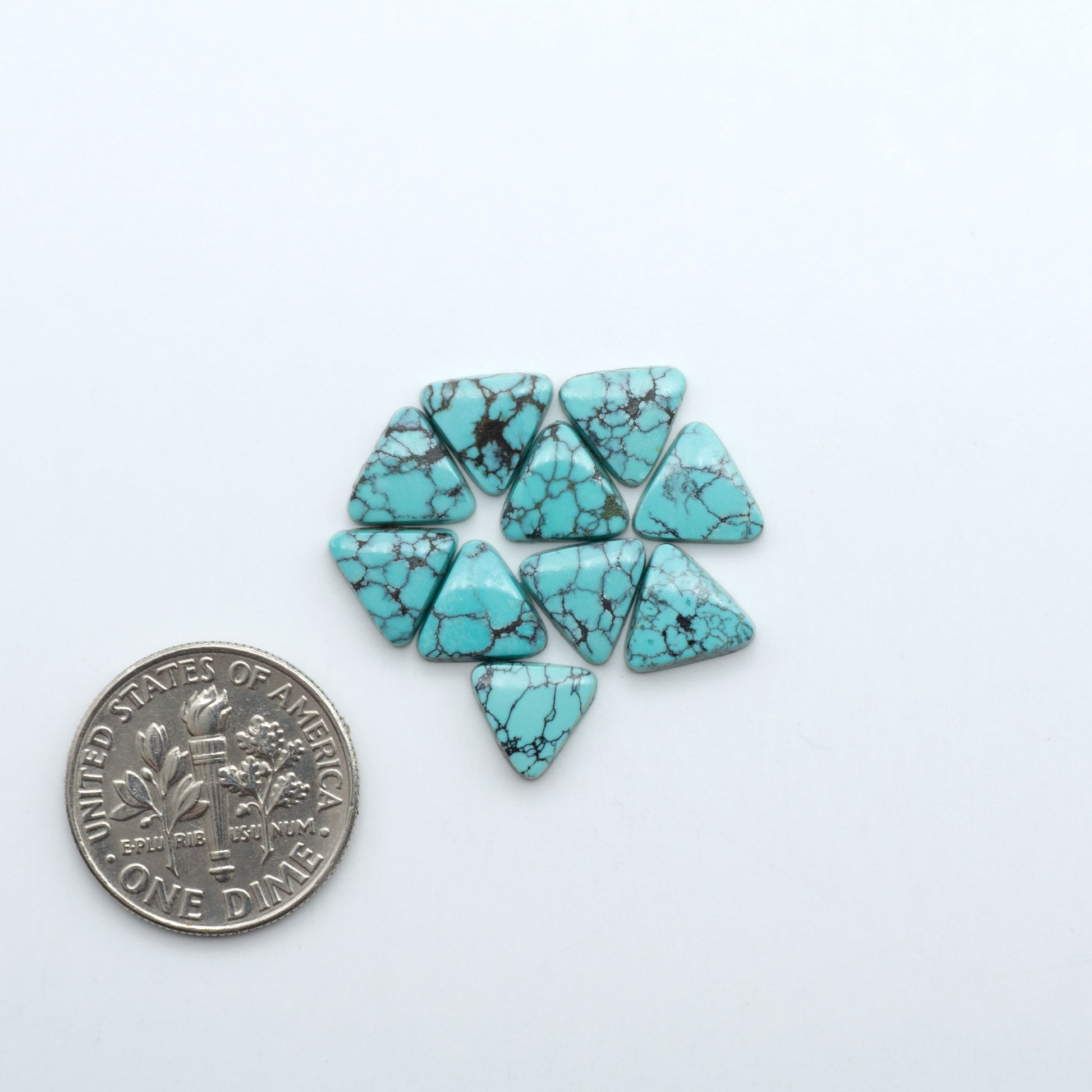 Hubei Cloud Mountain Turquoise cabochons, blue and green color with black matrix, polished stones on a white background with a US dime for scale
