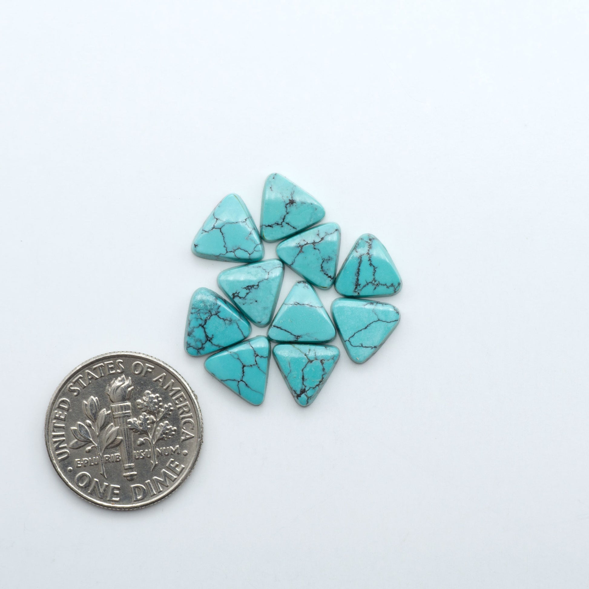 Hubei Cloud Mountain Turquoise cabochons, blue and green color with black matrix, polished stones on a white background with a US dime for scale