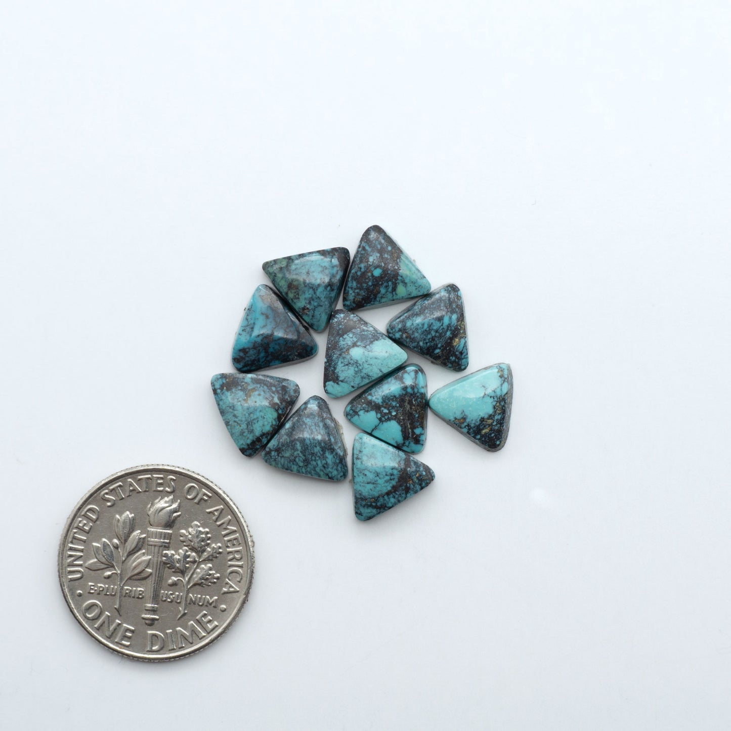 Hubei Cloud Mountain Turquoise cabochons, blue and green color with black matrix, polished stones on a white background with a US dime for scale