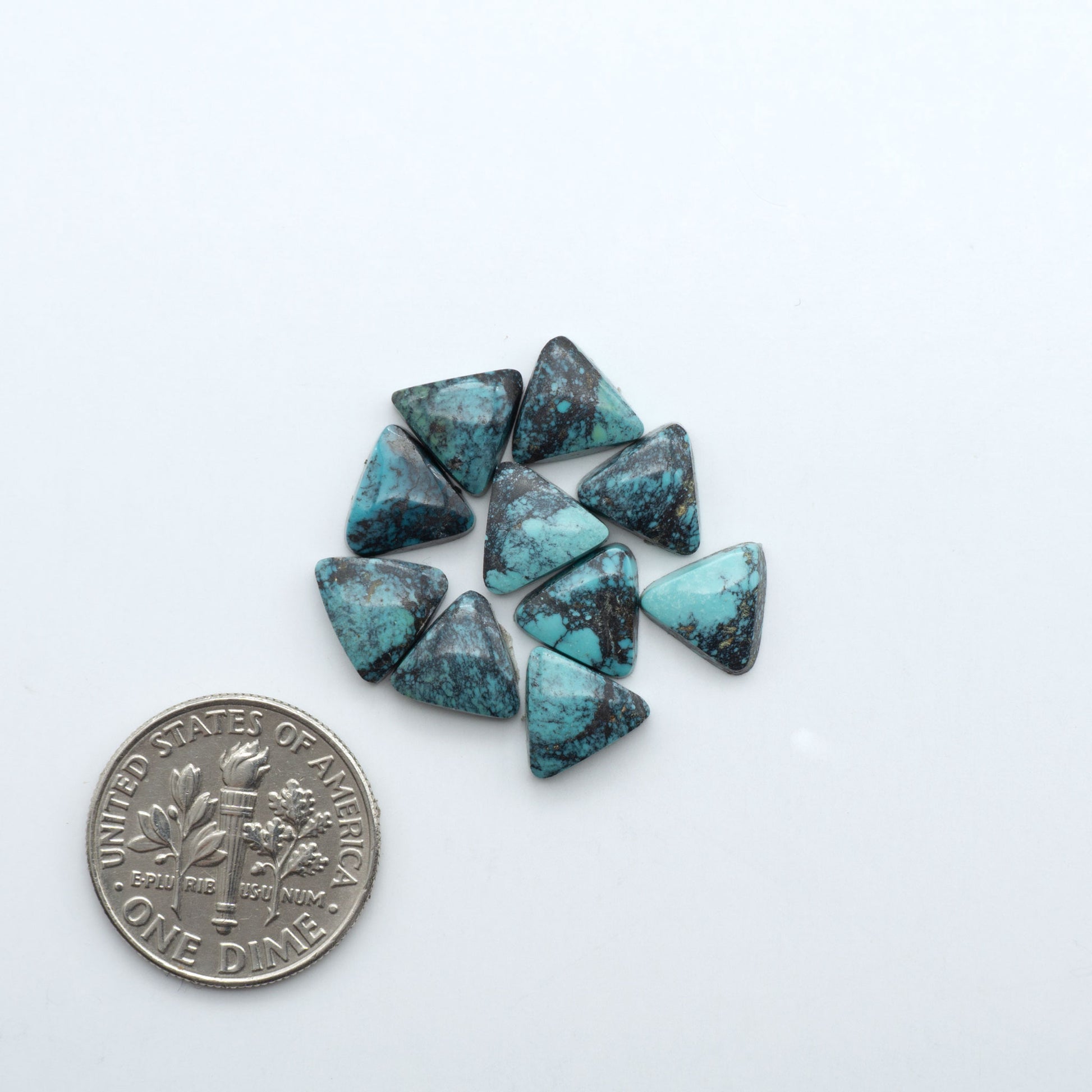 Hubei Cloud Mountain Turquoise cabochons, blue and green color with black matrix, polished stones on a white background with a US dime for scale