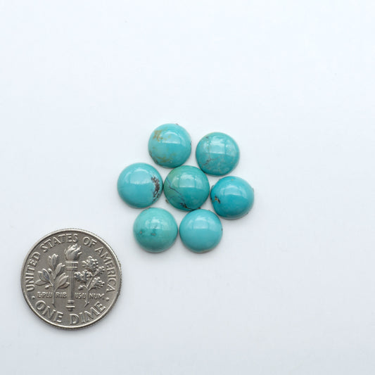 Hubei Cloud Mountain Turquoise cabochons, blue and green color with black matrix, polished stones on a white background with a US dime for scale