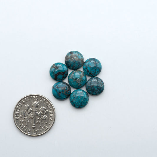 Hubei Cloud Mountain Turquoise cabochons, blue and green color with black matrix, polished stones on a white background with a US dime for scale
