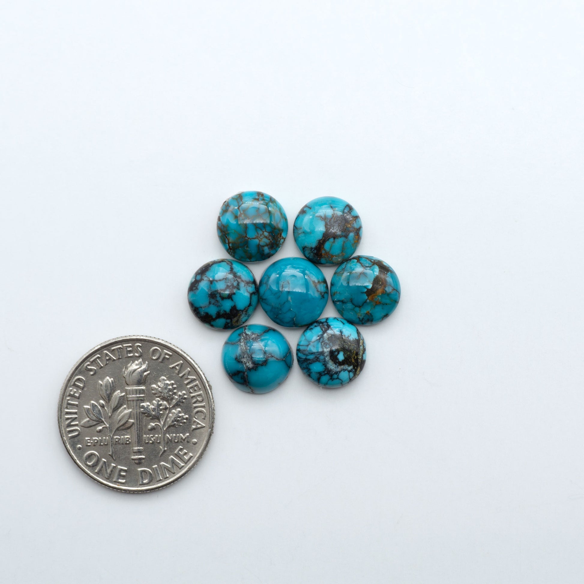 Hubei Cloud Mountain Turquoise cabochons, blue and green color with black matrix, polished stones on a white background with a US dime for scale