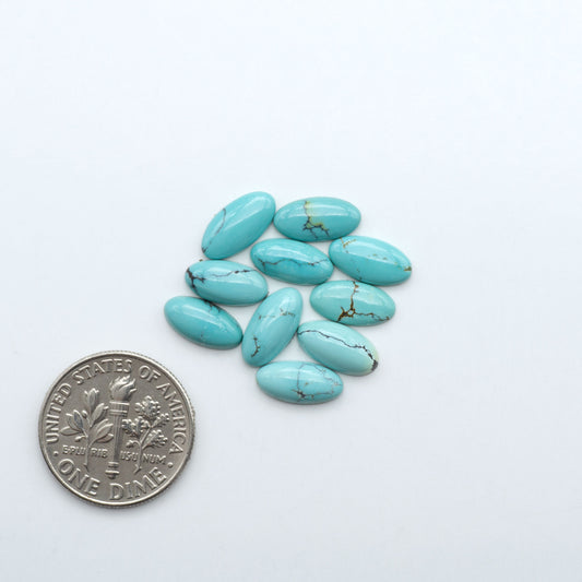 Hubei Cloud Mountain Turquoise cabochons, blue and green color with black matrix, polished stones on a white background with a US dime for scale