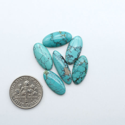 Hubei Cloud Mountain Turquoise cabochons, blue and green color with black matrix, polished stones on a white background with a US dime for scale