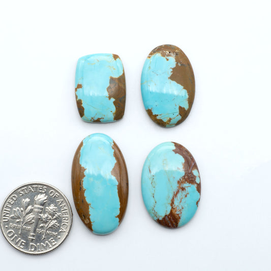 Number 8 Turquoise cabochons, blue and green color with brown matrix, polished stones on a white background, with a US dime for scale