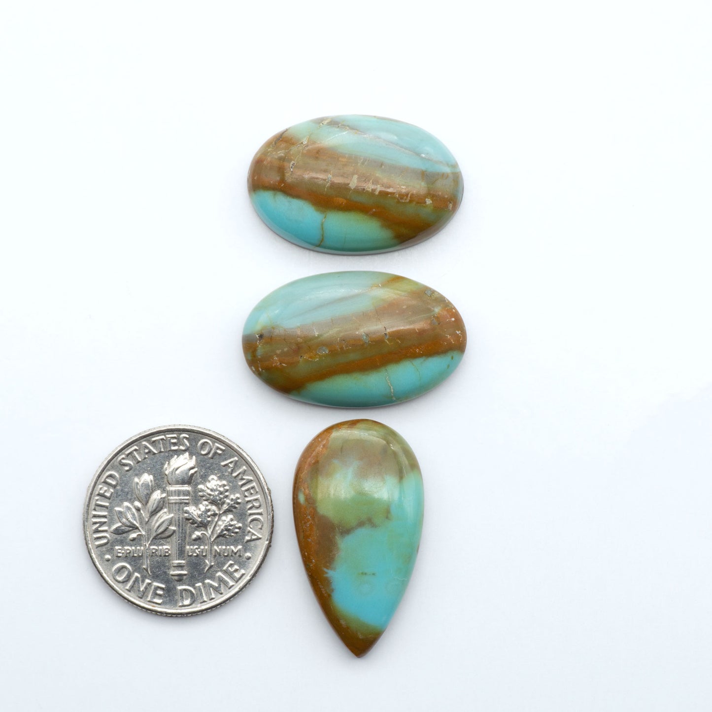 Number 8 Turquoise cabochons, blue and green color with brown matrix, polished stones on a white background, with a US dime for scale