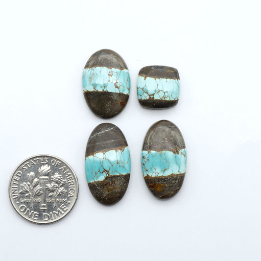 Number 8 Turquoise cabochons, blue and green color with brown matrix, polished stones on a white background, with a US dime for scale