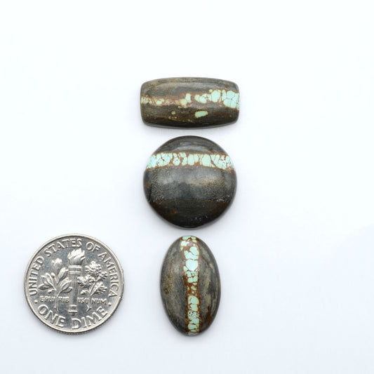 Number 8 Turquoise cabochons, blue and green color with brown matrix, polished stones on a white background, with a US dime for scale