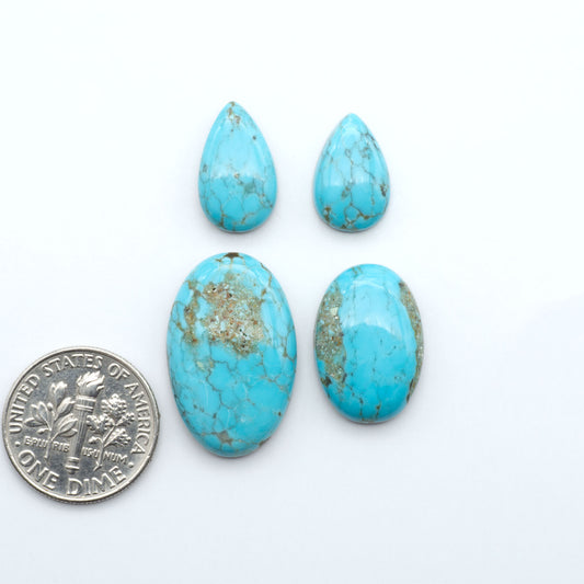 Number 8 Turquoise cabochons, blue and green color with brown matrix, polished stones on a white background, with a US dime for scale
