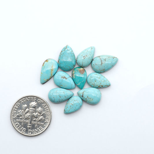 Number 8 Turquoise cabochons, blue and green color with brown matrix, polished stones on a white background, with a US dime for scale