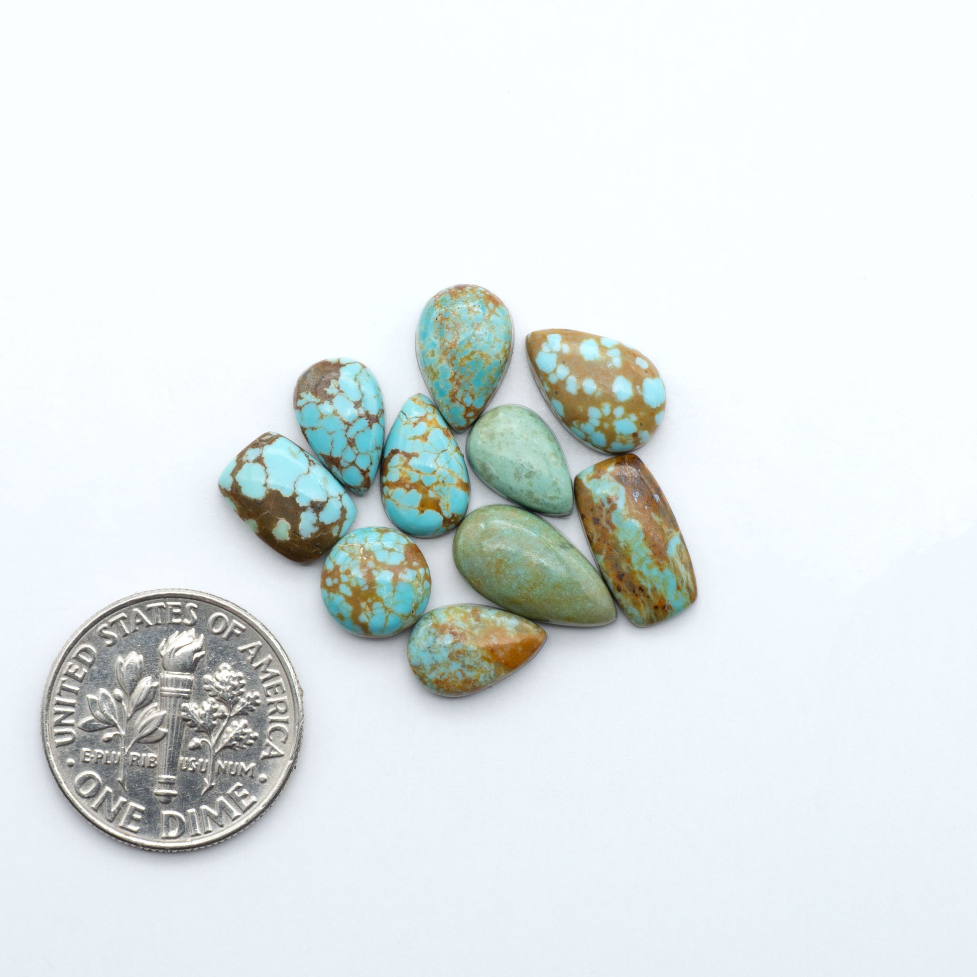 Number 8 Turquoise cabochons, blue and green color with brown matrix, polished stones on a white background, with a US dime for scale