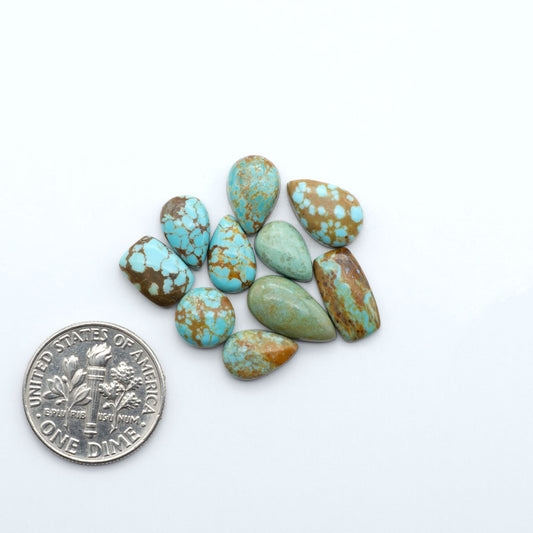 Number 8 Turquoise cabochons, blue and green color with brown matrix, polished stones on a white background, with a US dime for scale