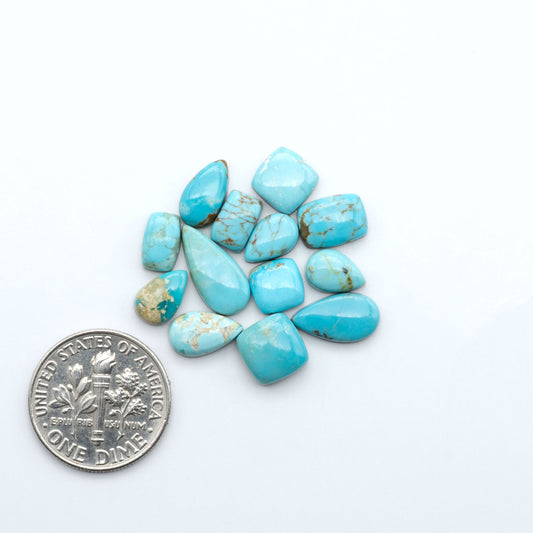 Number 8 Turquoise cabochons, blue and green color with brown matrix, polished stones on a white background, with a US dime for scale